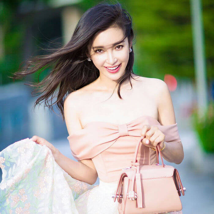 people-woman-A-pink top-B-smiling-C-holding handbag