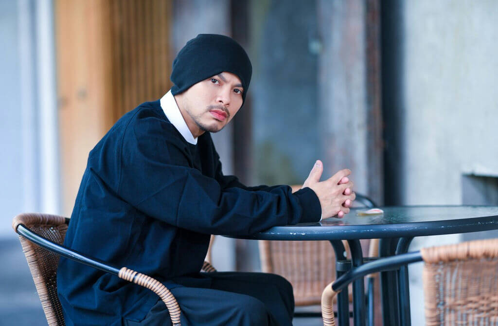 people-Man-A-Beanie-A-Black Shirt-A-Sitting at Table-B-Outdoor Cafe Setting