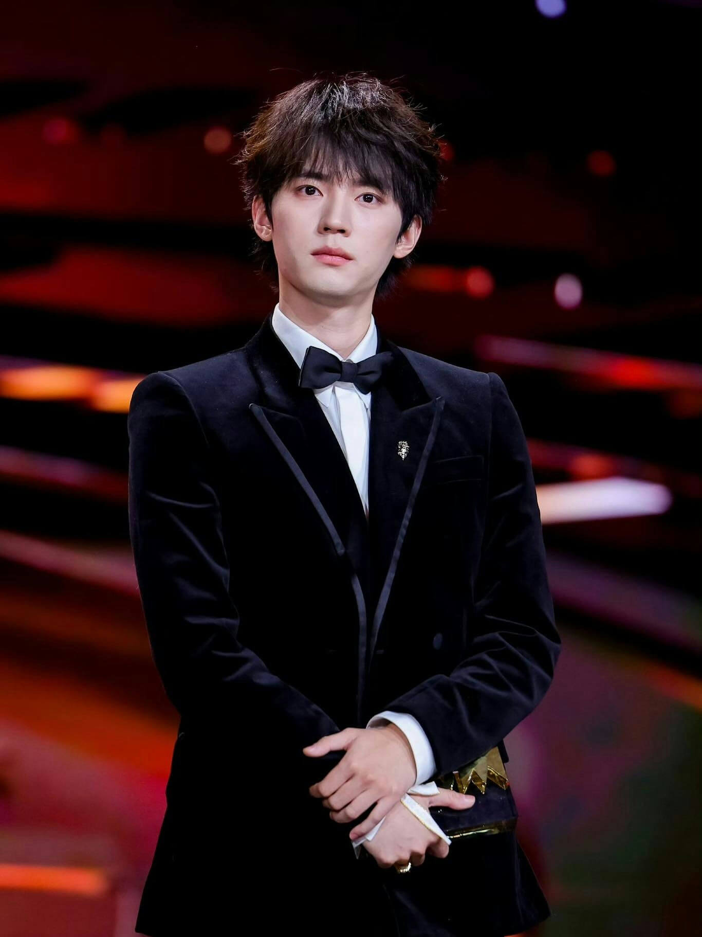 people-man-formal wear-black tuxedo-bow tie-standing-holding object