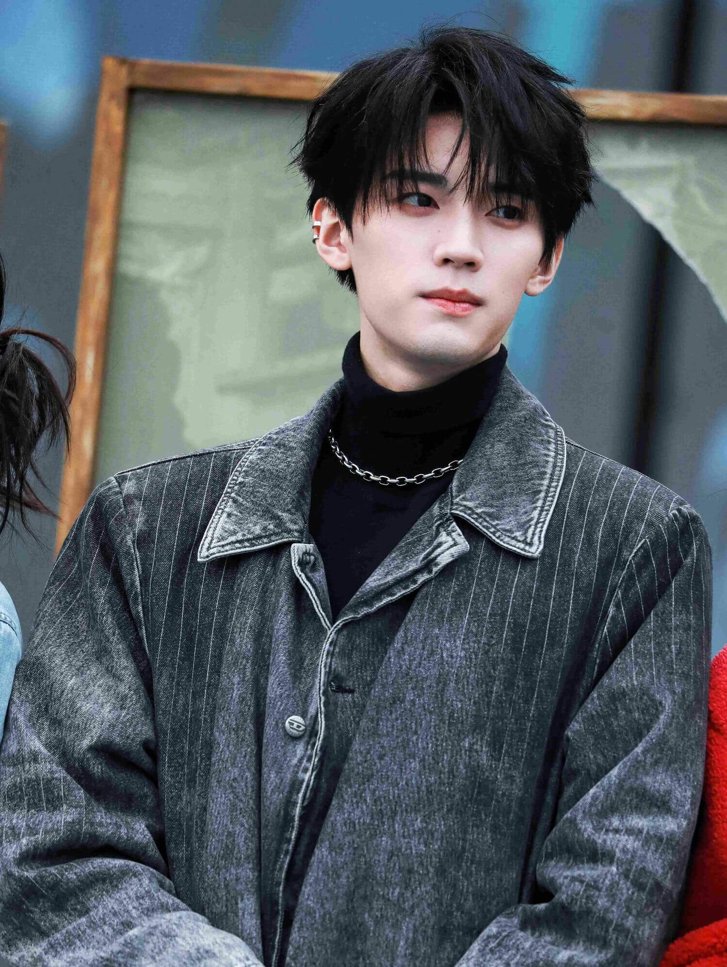 people-man-black hair-black turtleneck-pinstripe denim jacket-silver chain necklace-ear cuff