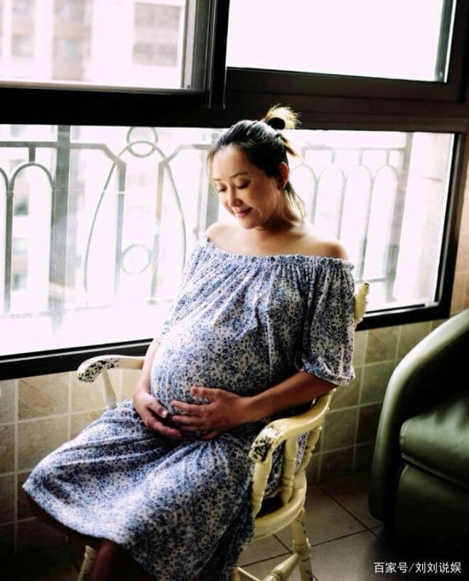people-A-pregnant woman-A-sitting-A-looking down-B-blue floral dress-B-indoor-C-window light