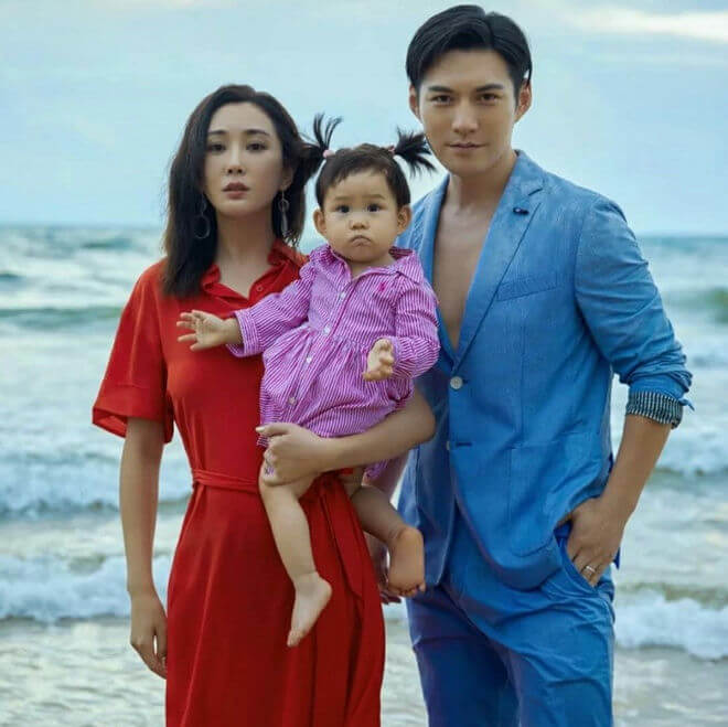 people-3-family portrait-A-beach setting-B-man in blue suit-C-woman in red dress-D-baby in striped dress