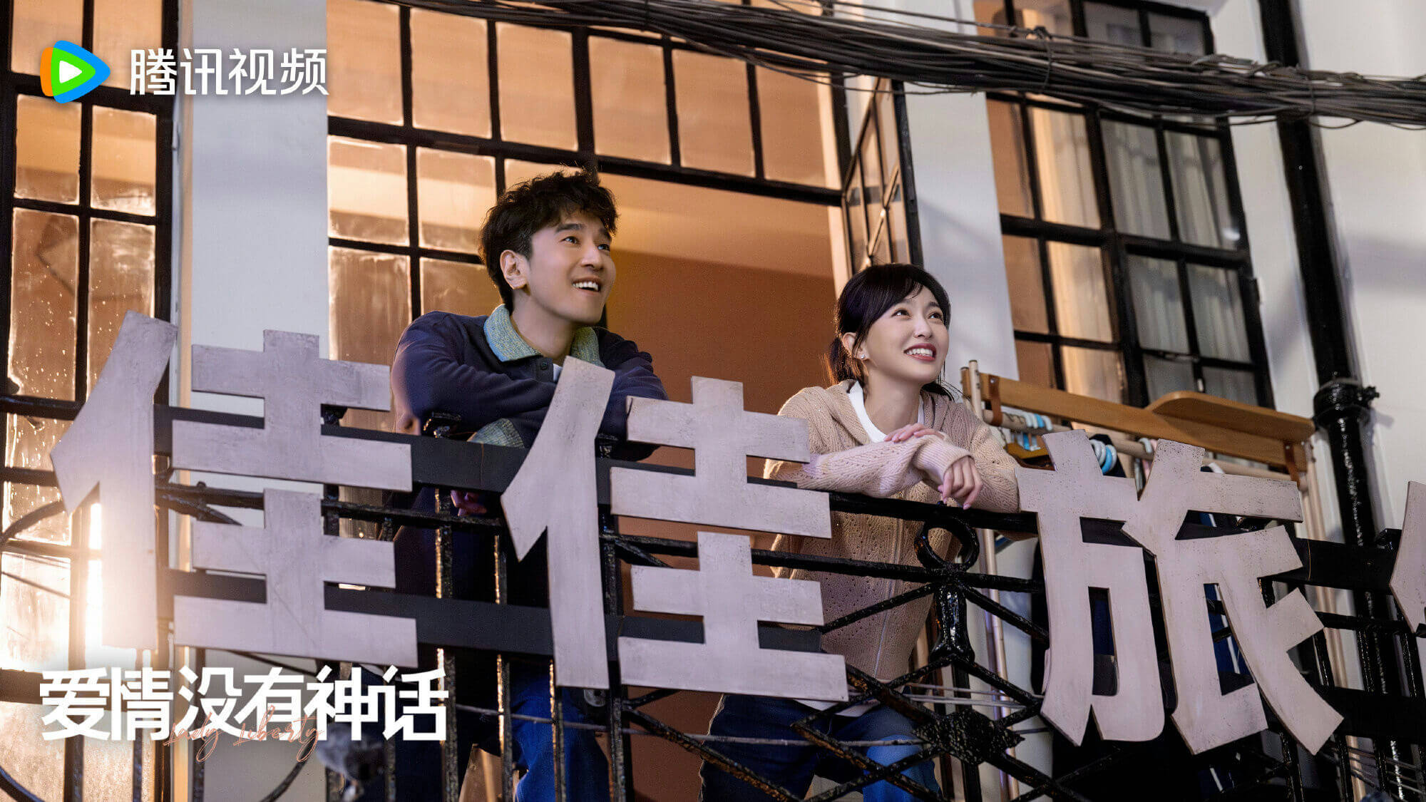people-A-smiling man-A-smiling woman-A-balcony railing-B-large Chinese characters-B-Tencent Video logo-C-Chinese text