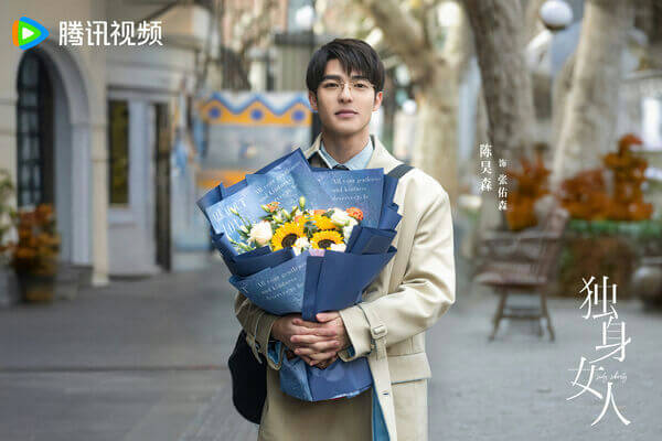 people-A-young man-A-holding flowers-A-wearing glasses-A-tan coat-B-outdoor setting-B-Chinese drama poster