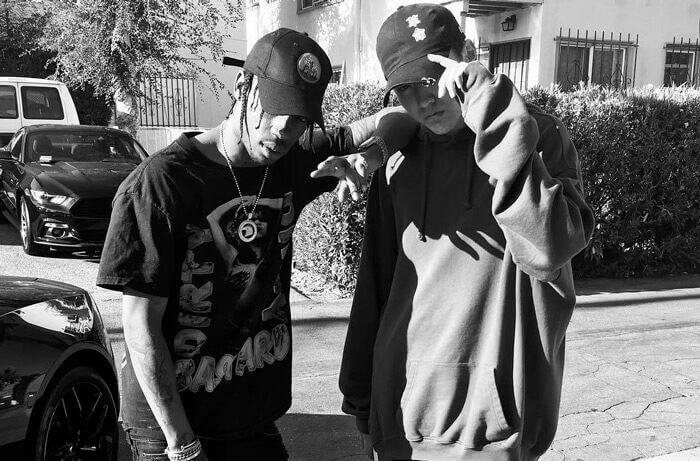 people-two young men-A-Travis Scott-A-casual streetwear-A-baseball caps-B-oversized hoodie-B-outdoor setting-C-black and white photography