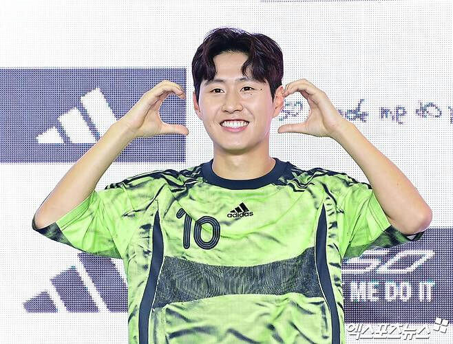 people-Asian man-A-smiling-A-wearing green and black soccer jersey-A-number 10-A-making heart shape with hands-B-Adidas logo visible-C