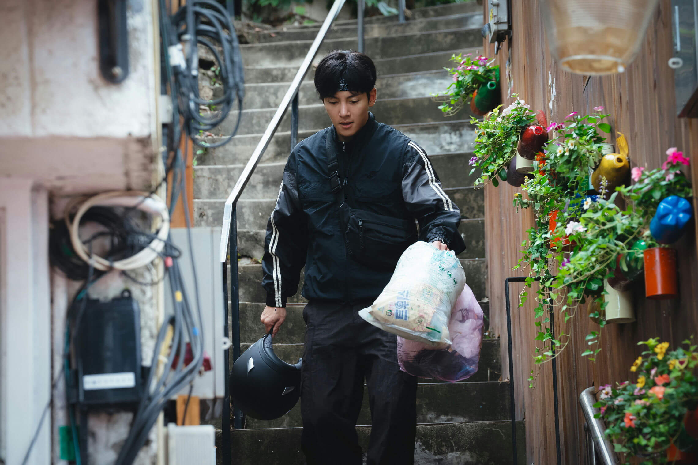 people-1-man-A-downward-gaze-A-carrying-garbage-bags-A-holding-helmet-A-walking-downstairs