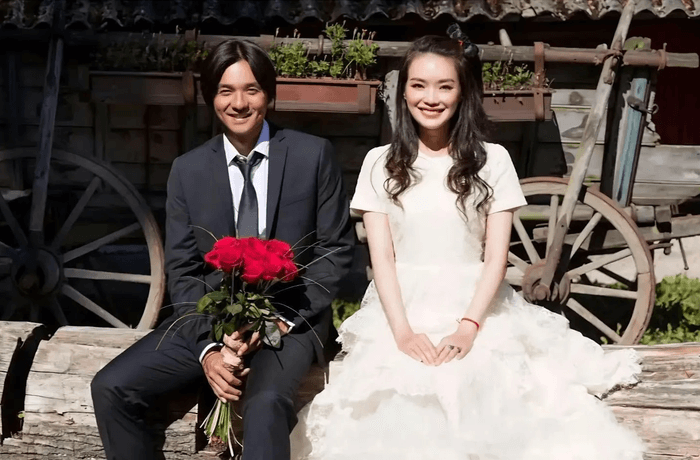 people-man and woman-A-sitting outdoors-B-holding red roses-C-wedding attire