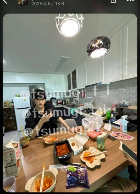 people-one male-A-sitting at a wooden table-A-eating food-A-indoor setting-A-kitchen in background