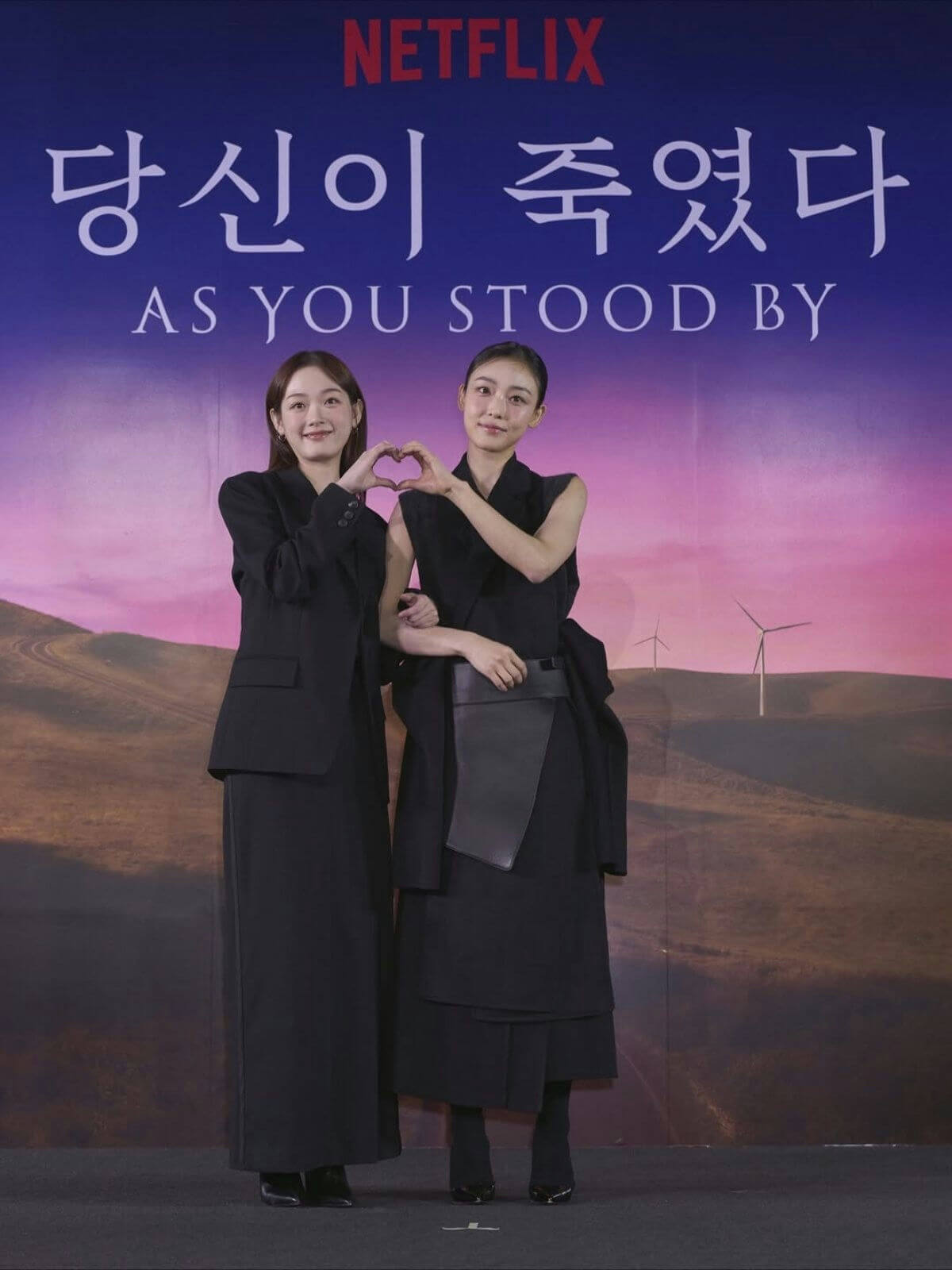 people-Two women-A-formal attire-A-black clothing-A-heart gesture-B-Netflix promotion-C-Korean drama