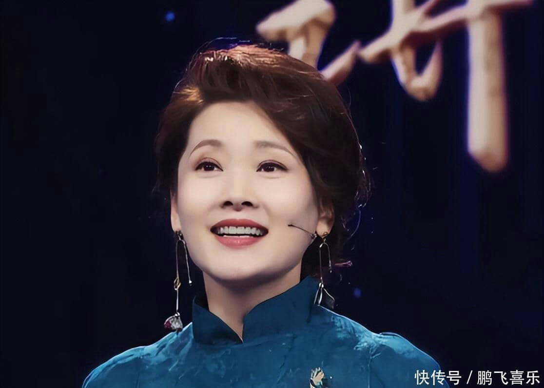 people-woman-smiling-on-stage-wearing-blue-dress-with-long-earrings