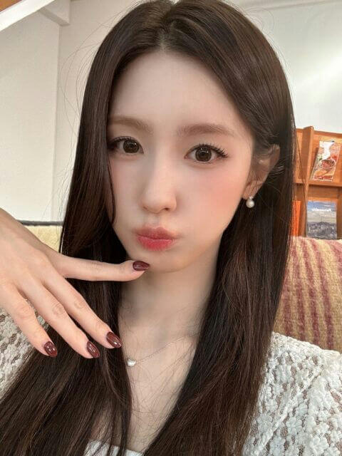people-A-woman-A-long dark hair-A-pout-A-pearl earring-A-dark red manicure-A-lace top