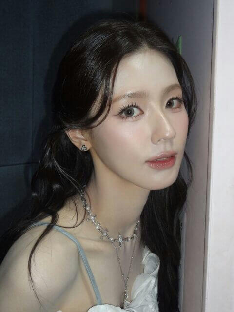 people-A-woman-A-dark hair-A-pigtails-A-jewelry-A-choker-A-pearls-A-light makeup-A-tank top