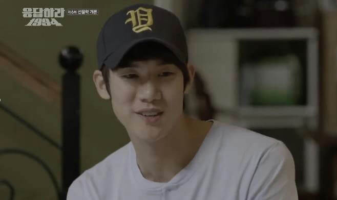 people-1-young man-A-wearing a baseball cap-A-wearing a white t-shirt-B-smiling slightly-C-Korean text overlay