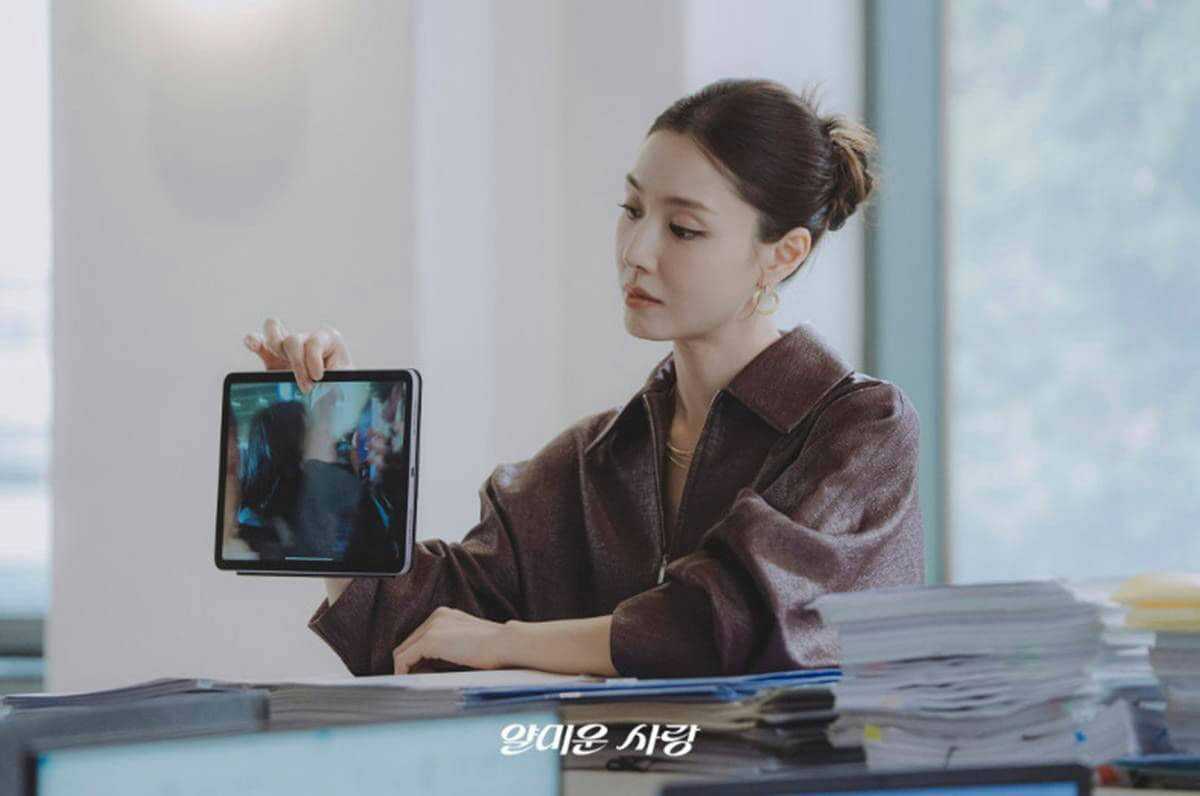 people-one woman-A-sitting at desk-B-holding tablet-C-Korean text visible