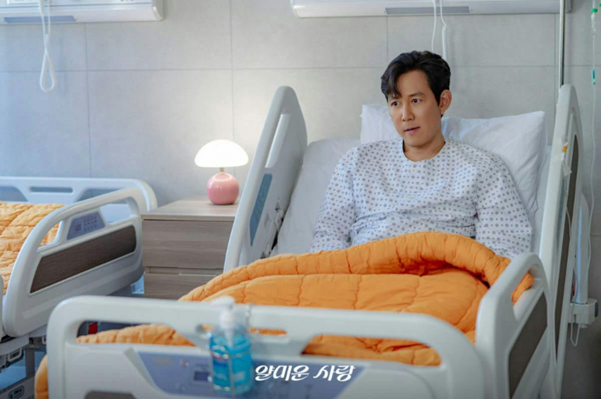 people-One man-A-hospital-A-patient gown-A-hospital bed-B-orange blanket-C-pink mushroom lamp