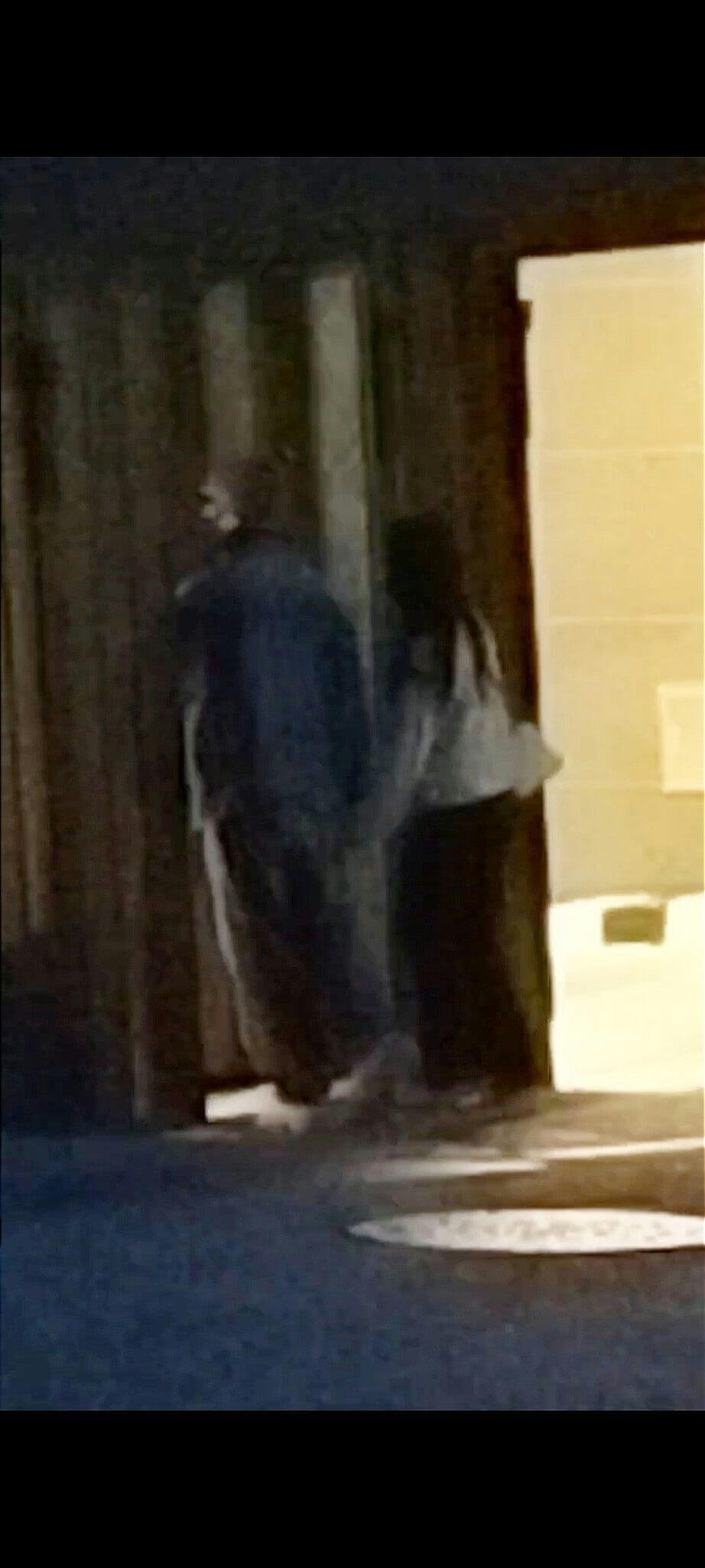 people-Two figures-A-dimly lit-A-entering doorway-A-dark setting