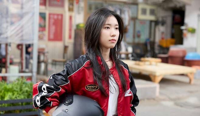 people-1-young woman-A-black and red jacket-A-holding helmet-A-outdoor setting
