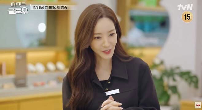 people-woman-dark brown hair-smiling-black collared shirt-name tag-Korean text overlay