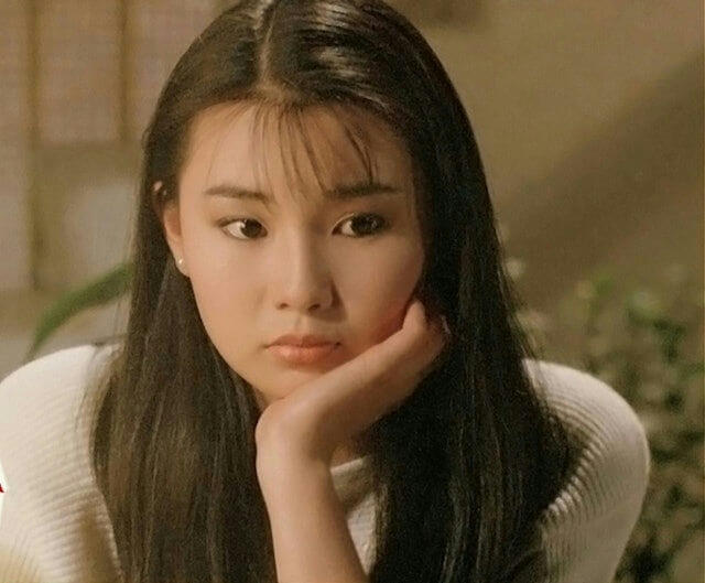 people-woman-long dark hair-holding chin-pensive expression-wearing white sweater