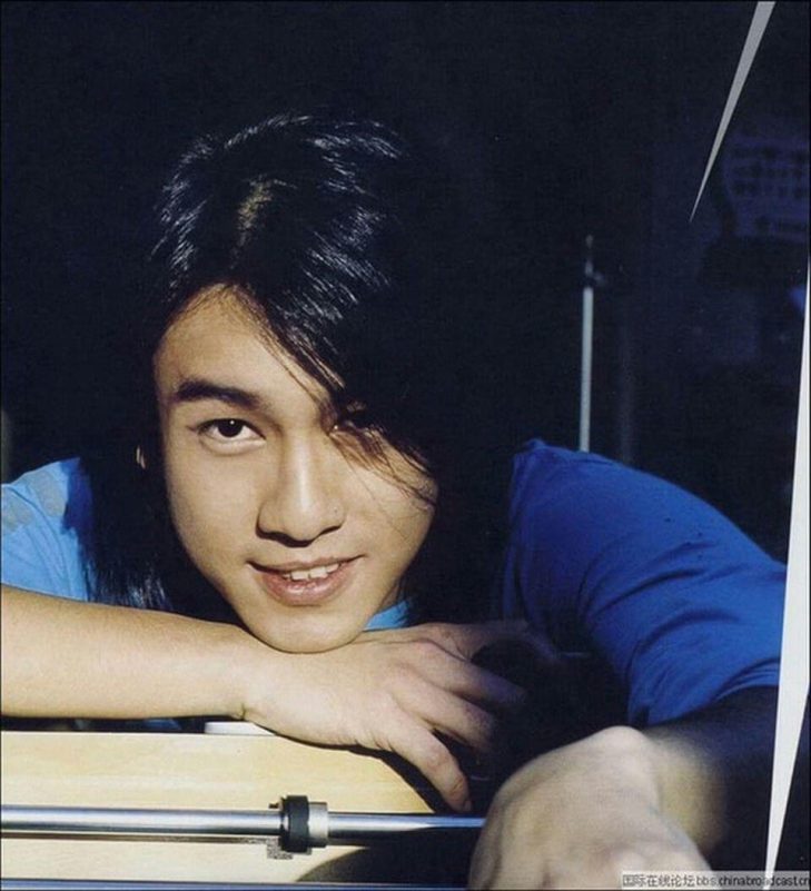 people-1-Asian male-A-long black hair-A-smiling-A-blue shirt-A-leaning forward