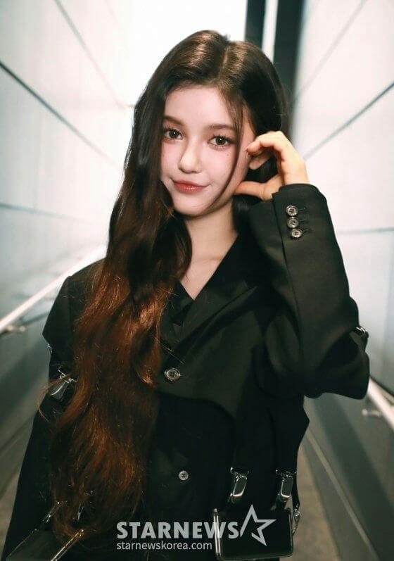 people-Young woman-A-long dark hair-B-black jacket-C-hand near face