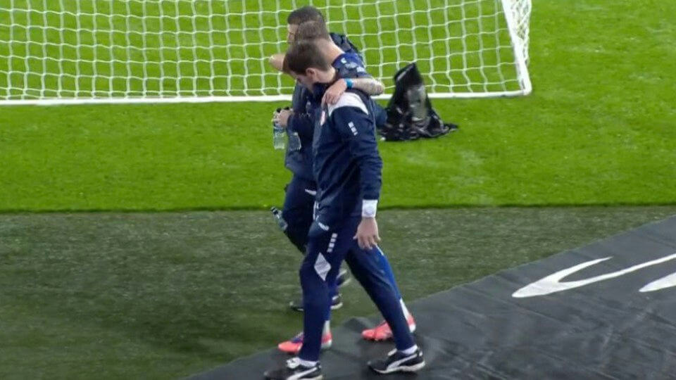 people-two-soccer-players-A-comforting-A-walking-off-field-A-football-net-visible
