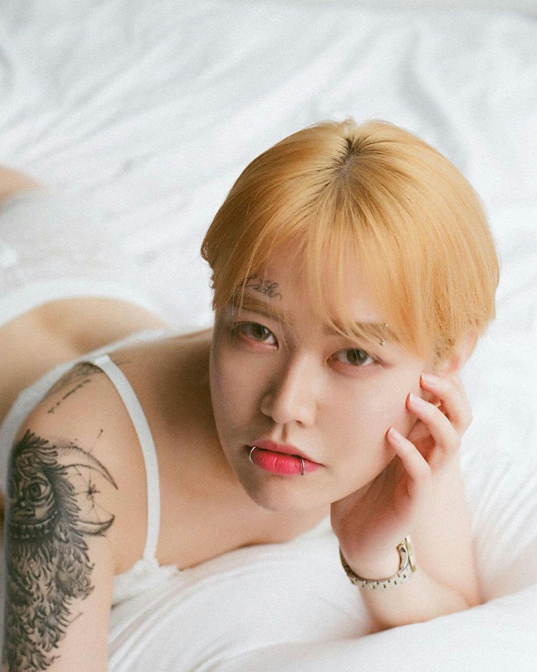 people-woman-A-blonde hair-A-lying down-B-tattoos-C