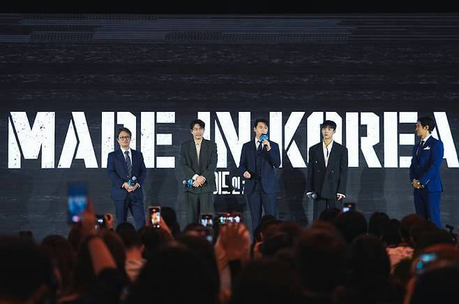 people-5 men on stage-audience in foreground-stage backdrop with text-event or presentation