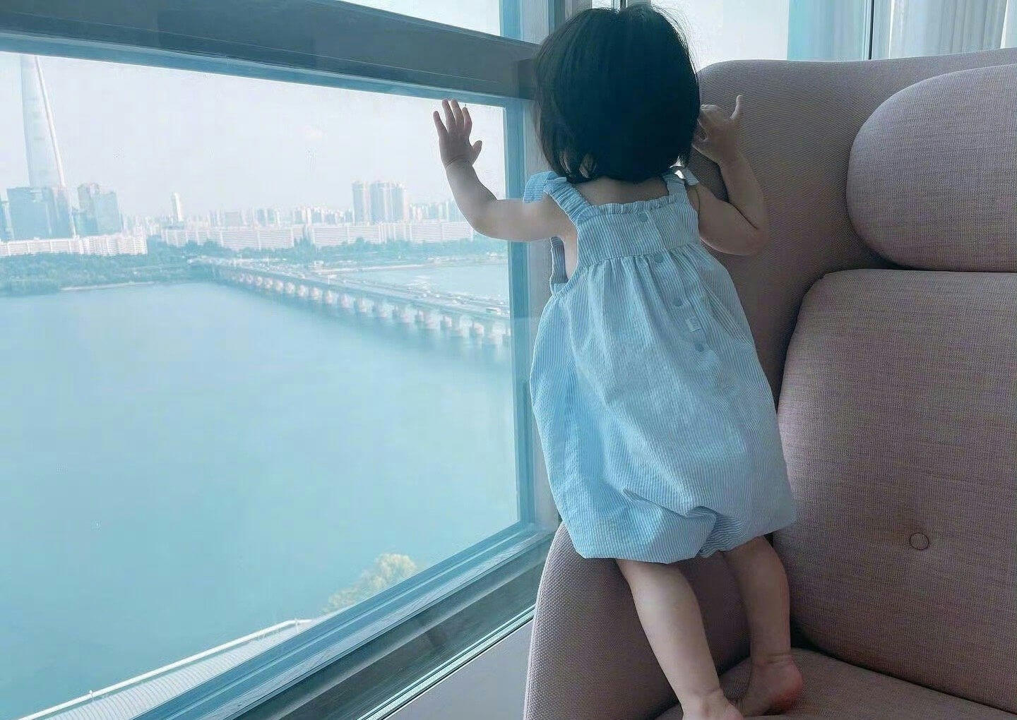 people-toddler-A-looking-A-out-A-window-A-cityscape
