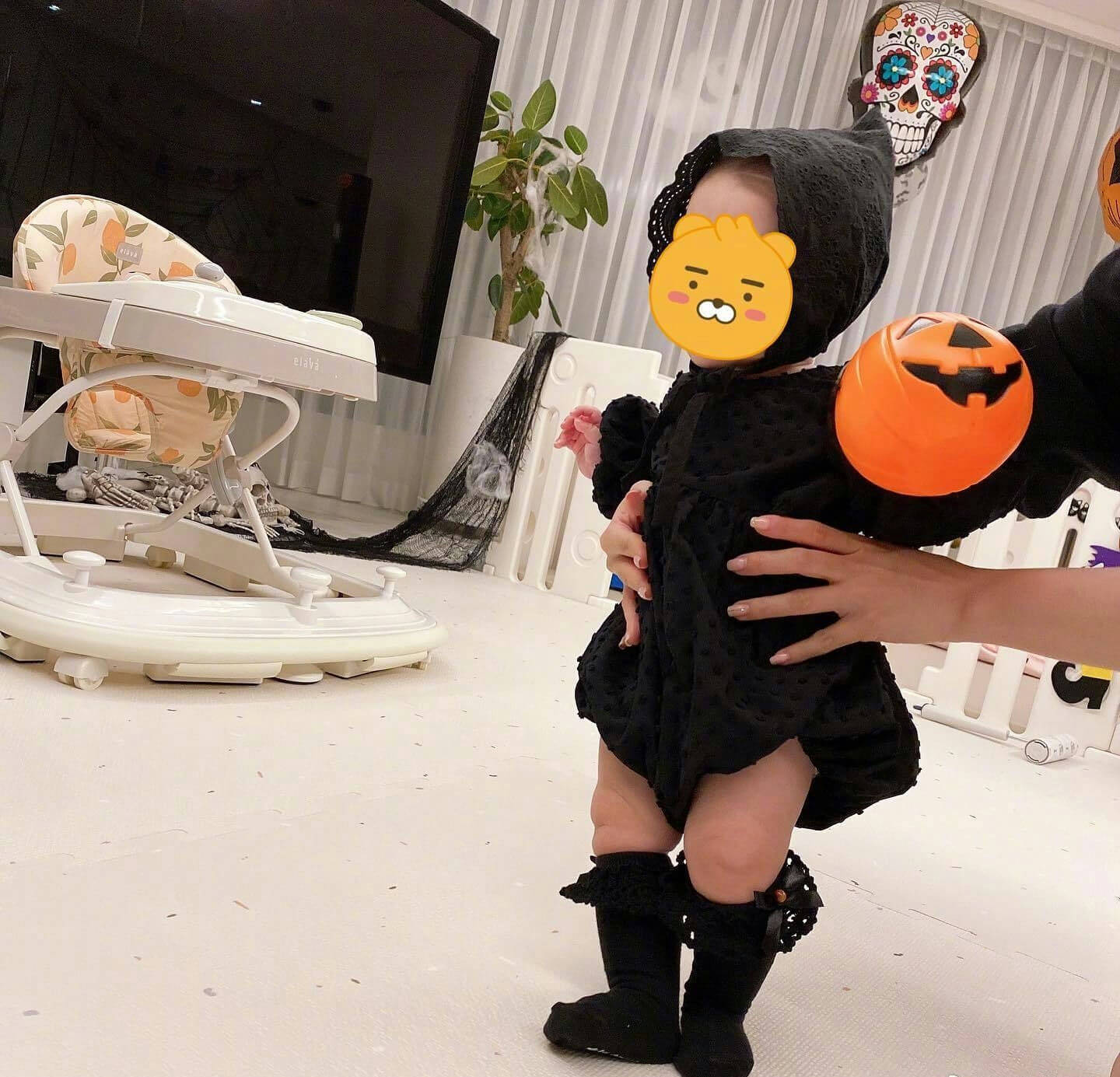people-A-baby in Halloween costume-A-holding pumpkin bucket-B-skeleton decorations-C-infant walker