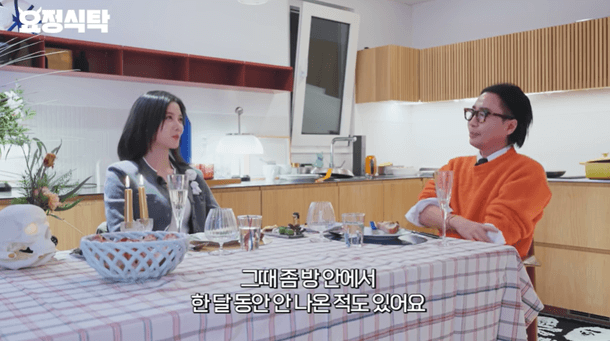 people-woman in grey jacket-A-man in orange sweater-A-dining table-A-kitchen background-A-Korean subtitles
