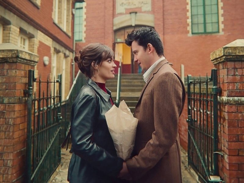 people-A-couple-A-looking-at-each-other-B-holding-flowers-in-paper-C-outside-brick-building