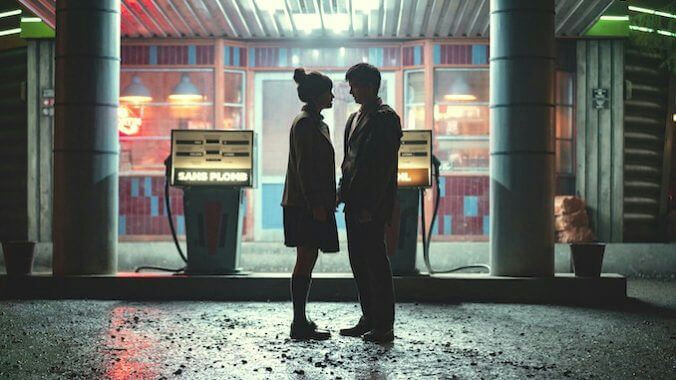 people-two young people-A-facing each other-A-silhouetted-B-gas station at night-C-wet ground