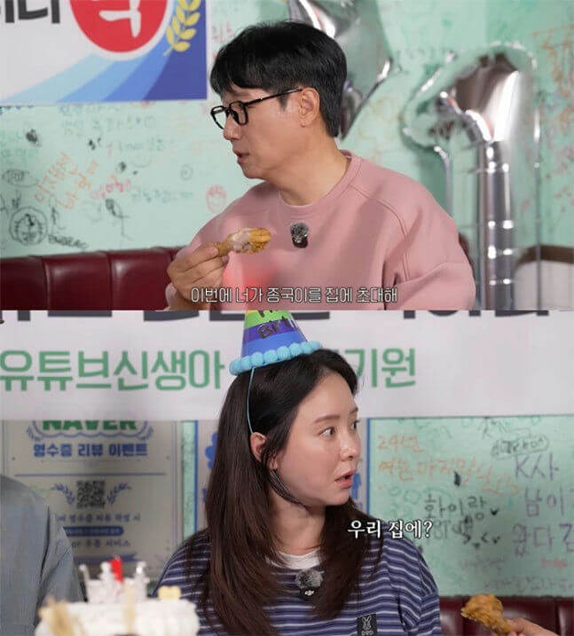 people-Man in pink shirt holding fried chicken and wearing glasses-Man-Man eating-Woman in striped shirt wearing a party hat-Woman-Woman looking surprised