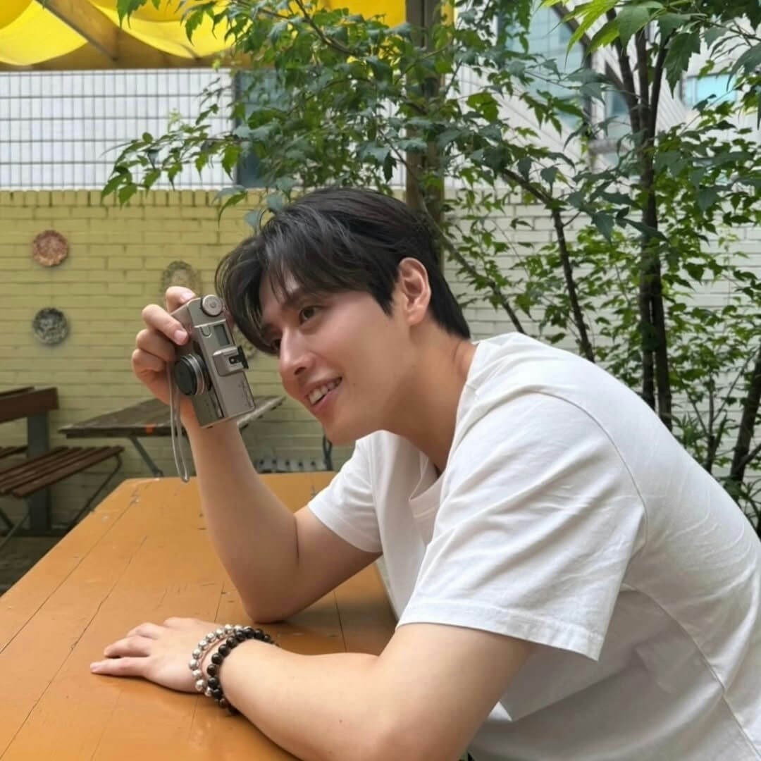 people-1-man-A-holding camera-A-smiling-A-wearing white shirt