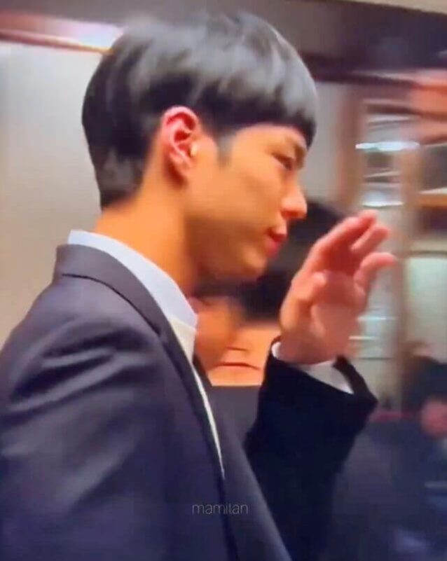 people-Asian man-A-dark bowl cut hairstyle-B-wearing a dark suit and white shirt-C-raising his right hand