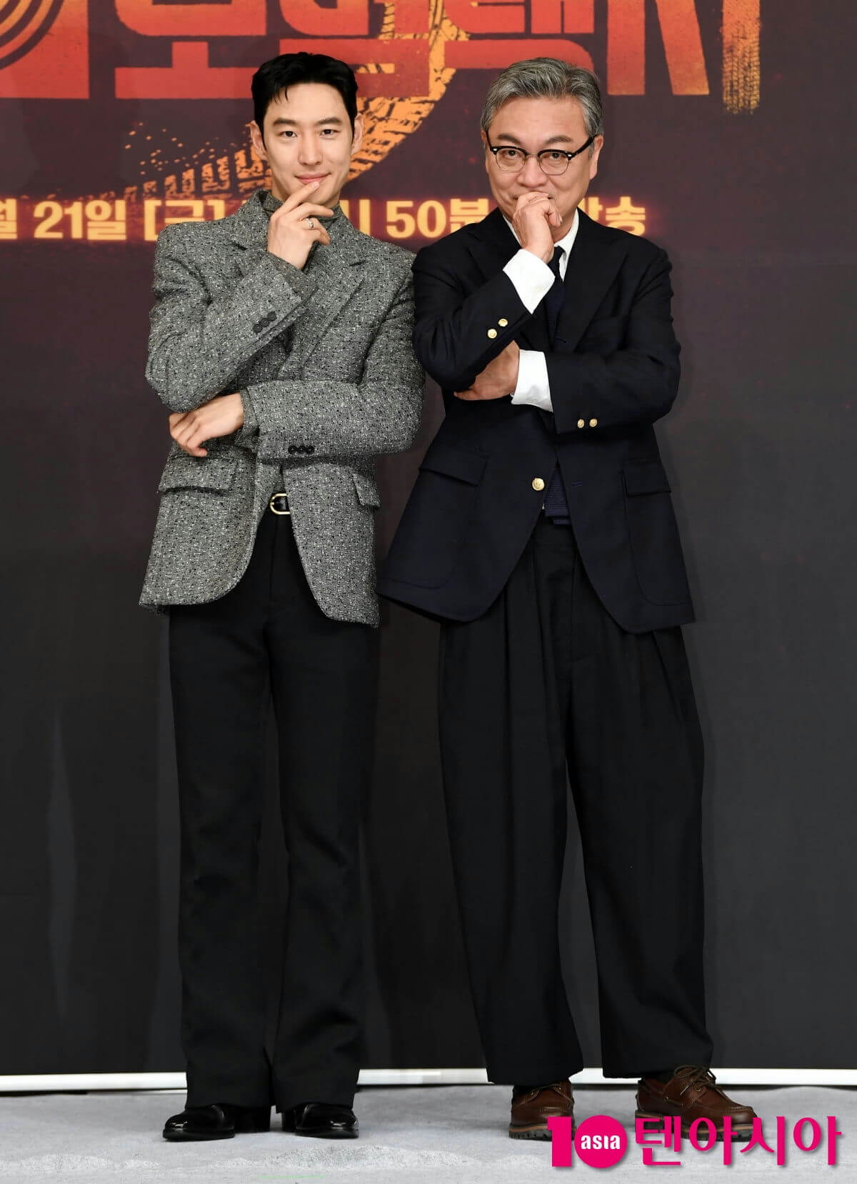 people-two men-A-formal wear-B-hand on chin pose-C-standing in front of dark backdrop