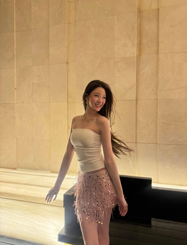 people-A-woman-A-smiling-A-strapless top-A-sequined fringe skirt-A-long dark hair-A-indoors