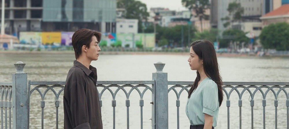 people-two-man-woman-standing-outdoors-railing-water-cityscape