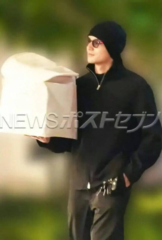 people-one man-A-holding white bag-B-wearing black beanie and sunglasses-C-wearing black quarter-zip top