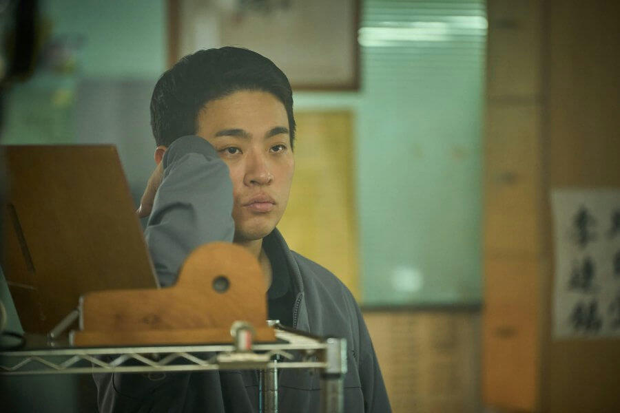 people-A-Asian male-A-pensive expression-B-gray jacket-C-indoor setting