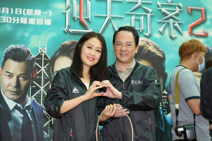 people-woman-smiling-and-making-heart-shape-with-man-and-man-smiling-and-making-heart-shape-with-woman-and-person-wearing-mask-and-holding-camera