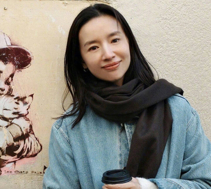 people-woman-A-black scarf-A-denim jacket-A-coffee cup-A-street art