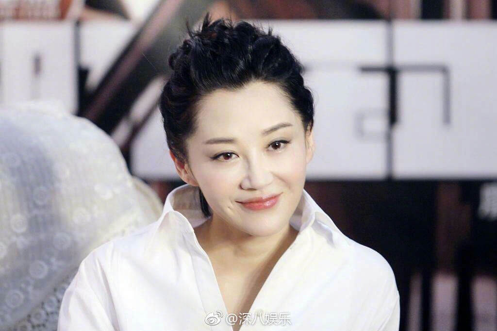 people-A-female celebrity-A-Asian woman-A-black hair styled up-A-white collared shirt-A-smiling slightly