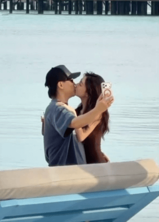 people-Two people-A-kissing-A-holding a phone-A-taking a selfie-B-standing in water-C-beach setting