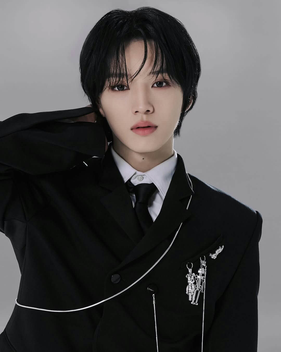 people-A-male K-pop idol-A-black hair-A-black suit and tie-A-silver chain and brooches