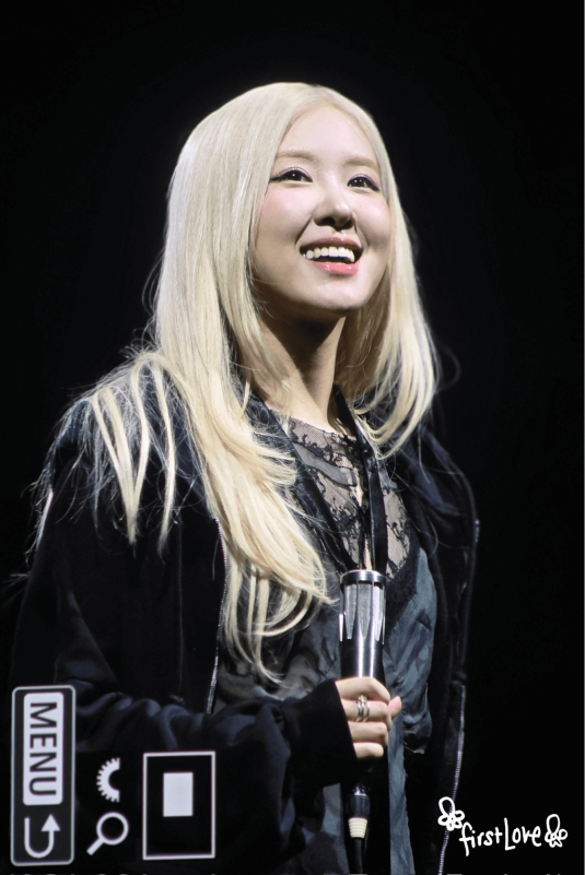 people-woman-blonde hair-A-smiling-B-holding microphone-C-black outfit