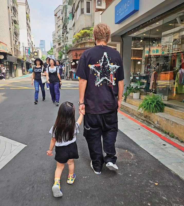 people-1-man-walking-with-child-2-girl-holding-hand-3-group-of-women-in-background