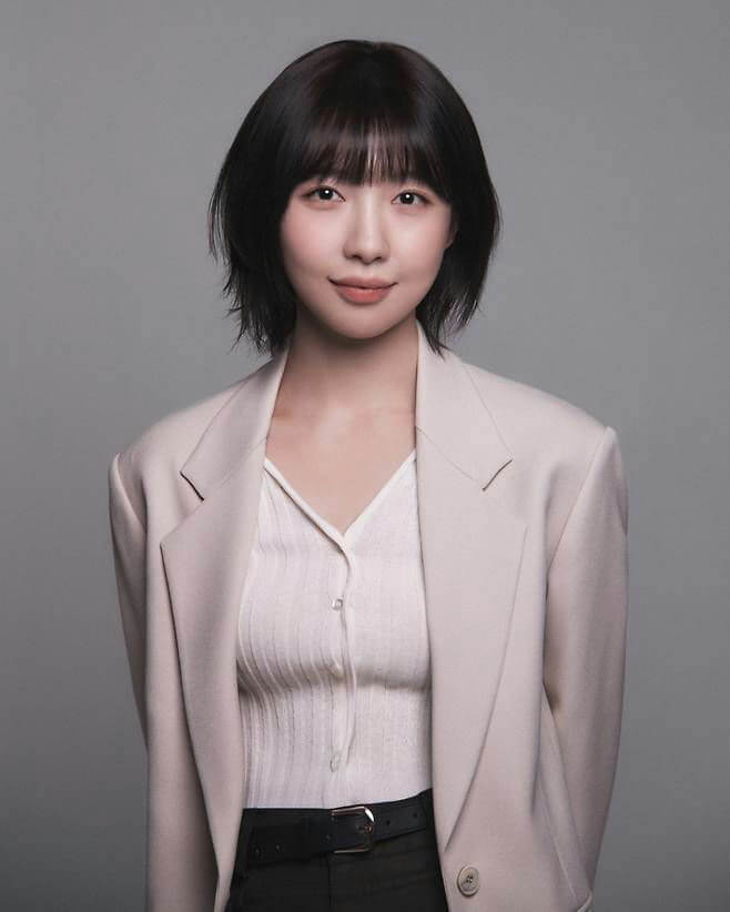 people-woman-short black hair with bangs-professional attire-light beige blazer-white ribbed top-studio portrait